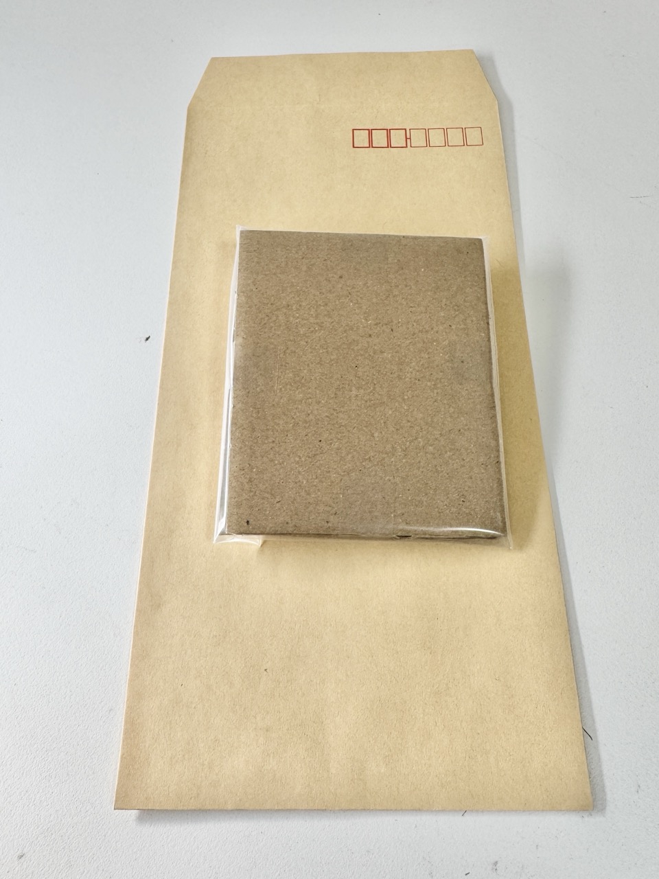 Protected cards slide into a sturdy kraft
                    envelope.